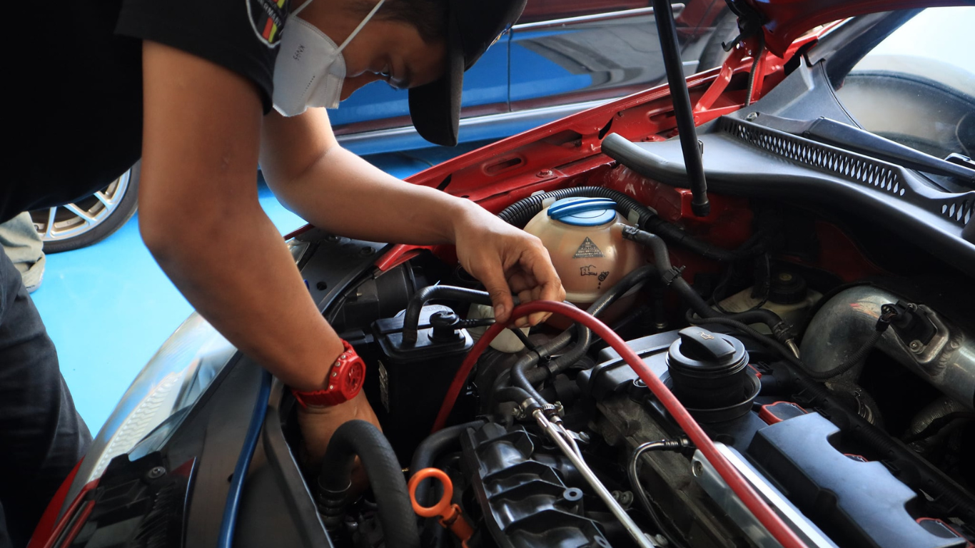 This image placed on (Pre Purchase Inspection). It shows one personnel infront of the car during inspection and maintenance