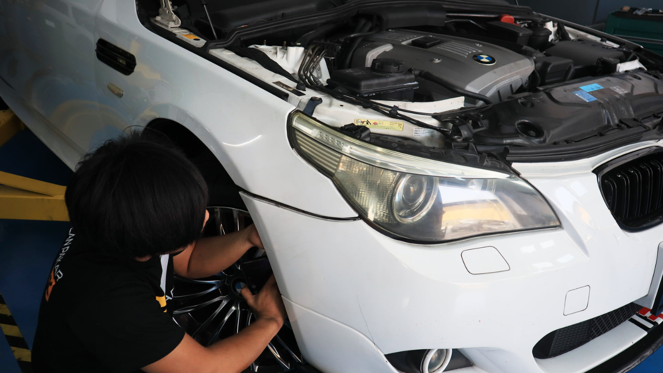 This image placed on (Pre Purchase Inspection). It shows one personnel infront of the car during inspection and tyre maintenance